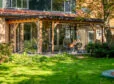 Veranda aan huis in een grote tuin met glazen schuifwand