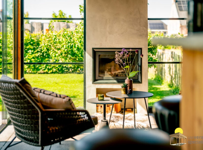 Veranda met houtkachel 3 Zonnige veranda met lichte houtkachel en staal details