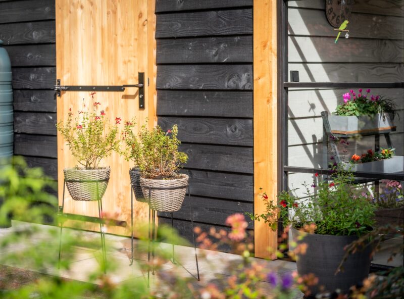 Veranda met kleine berging 3 Veranda met kleine berging met zwart hout en planten in de tuin