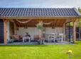 Kapschuur overkapping met wit-houten look vooraanzicht in de tuin