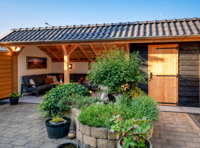 kapschuur overkapping 7 Kapschuur overkapping met groene planten in de tuin