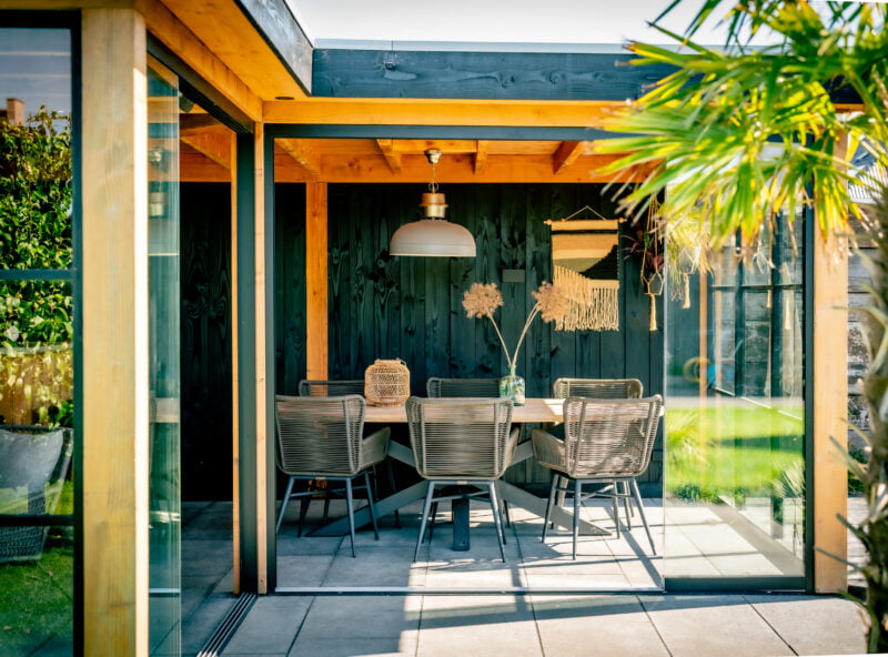 Moderne tuinkamer 7 Moderne tuinkamer met zwarte achterwand en glazen schuifwand