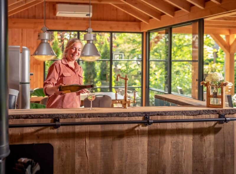 Overkapping met buitenkeuken 4 Overkapping met buitenkeuken en vrouw die een wijnglas inschenkt