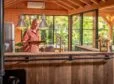 Overkapping met buitenkeuken en vrouw die een wijnglas inschenkt